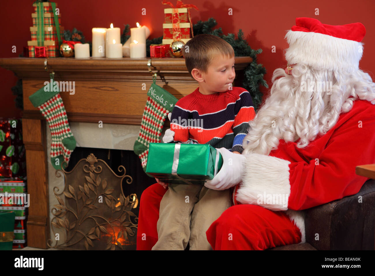 Santa Claus gives young boy Christmas gift Stock Photo