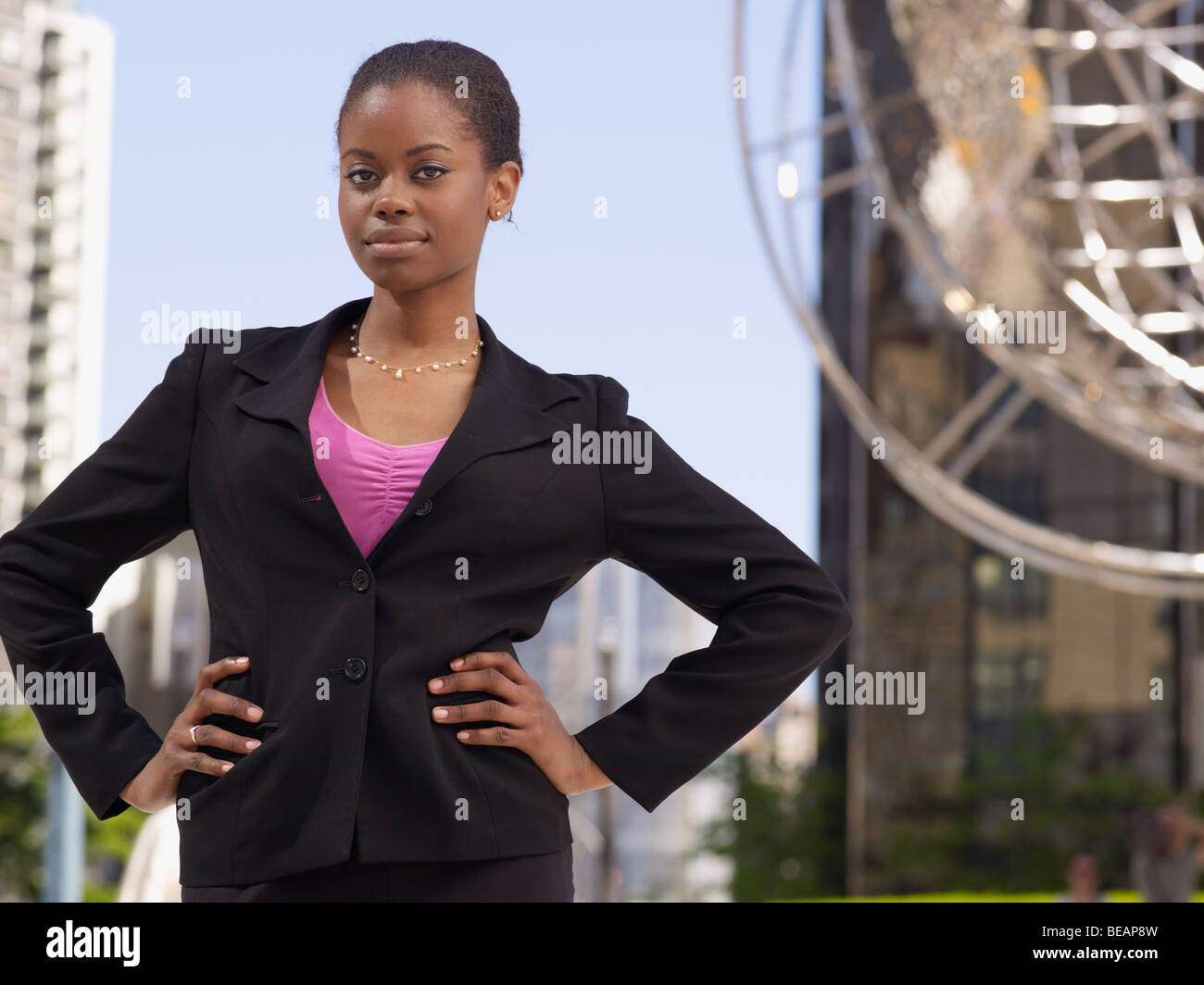 Confident African businesswoman with hands on hips Stock Photo