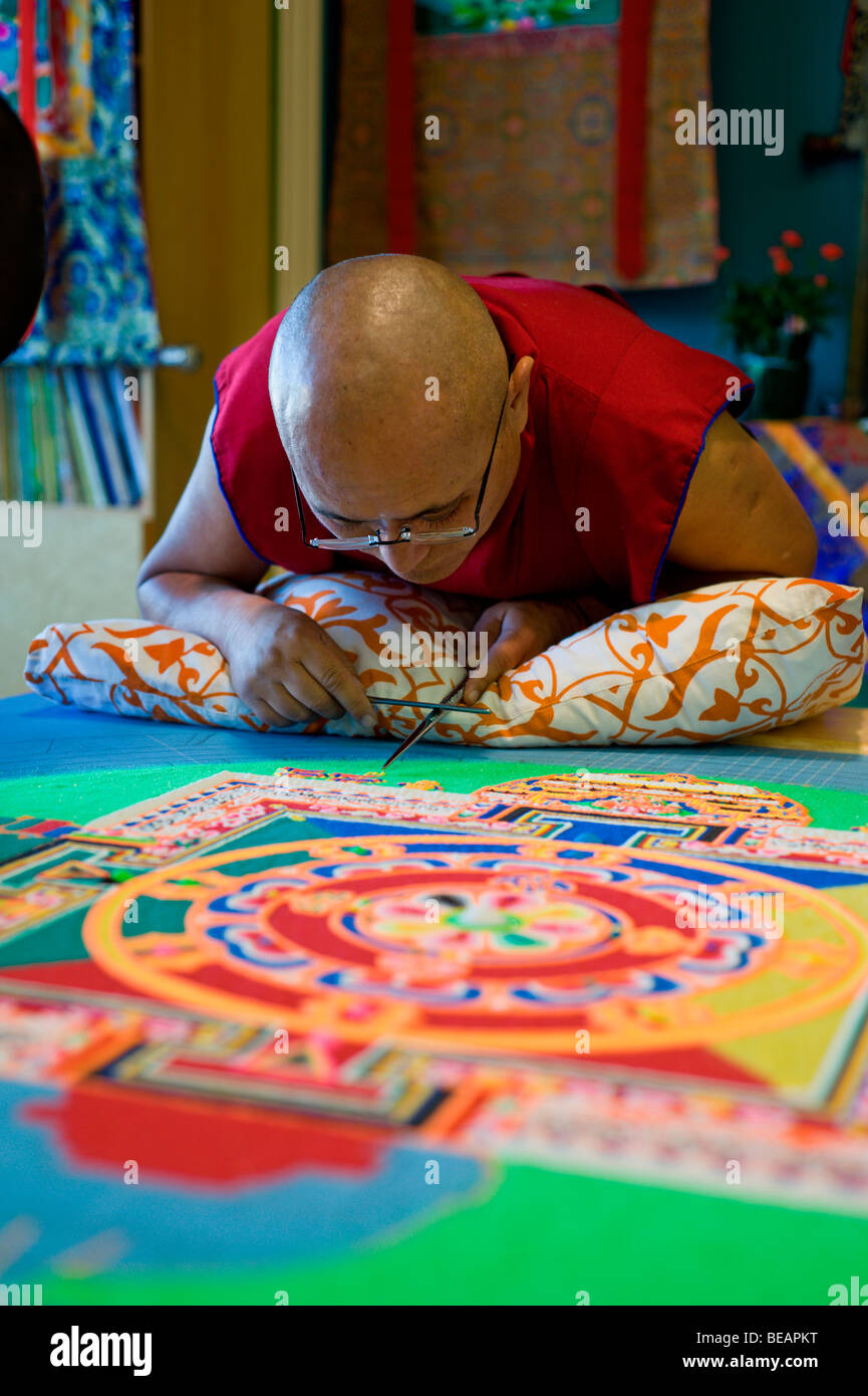 Tibetan Monk VenoDhondup Tsering carefully works on a colorful Sand Mandala in Ruidoso, New Mexico. Stock Photo