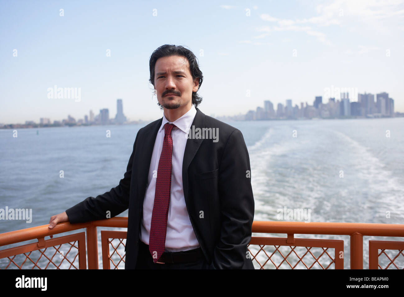 Mixed race businessman on ferry Stock Photo