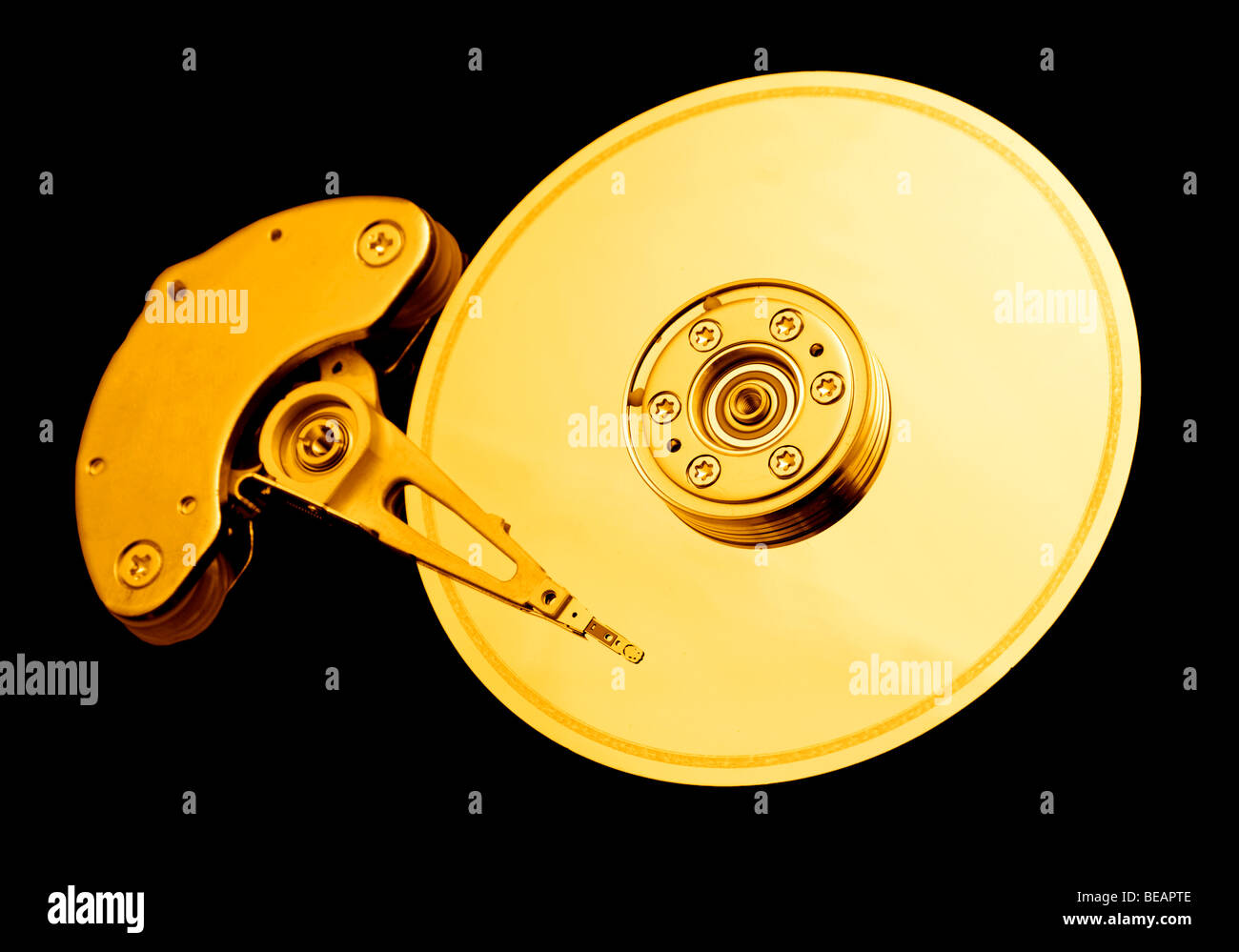 Open hard disk drive, with a golden tone Stock Photo