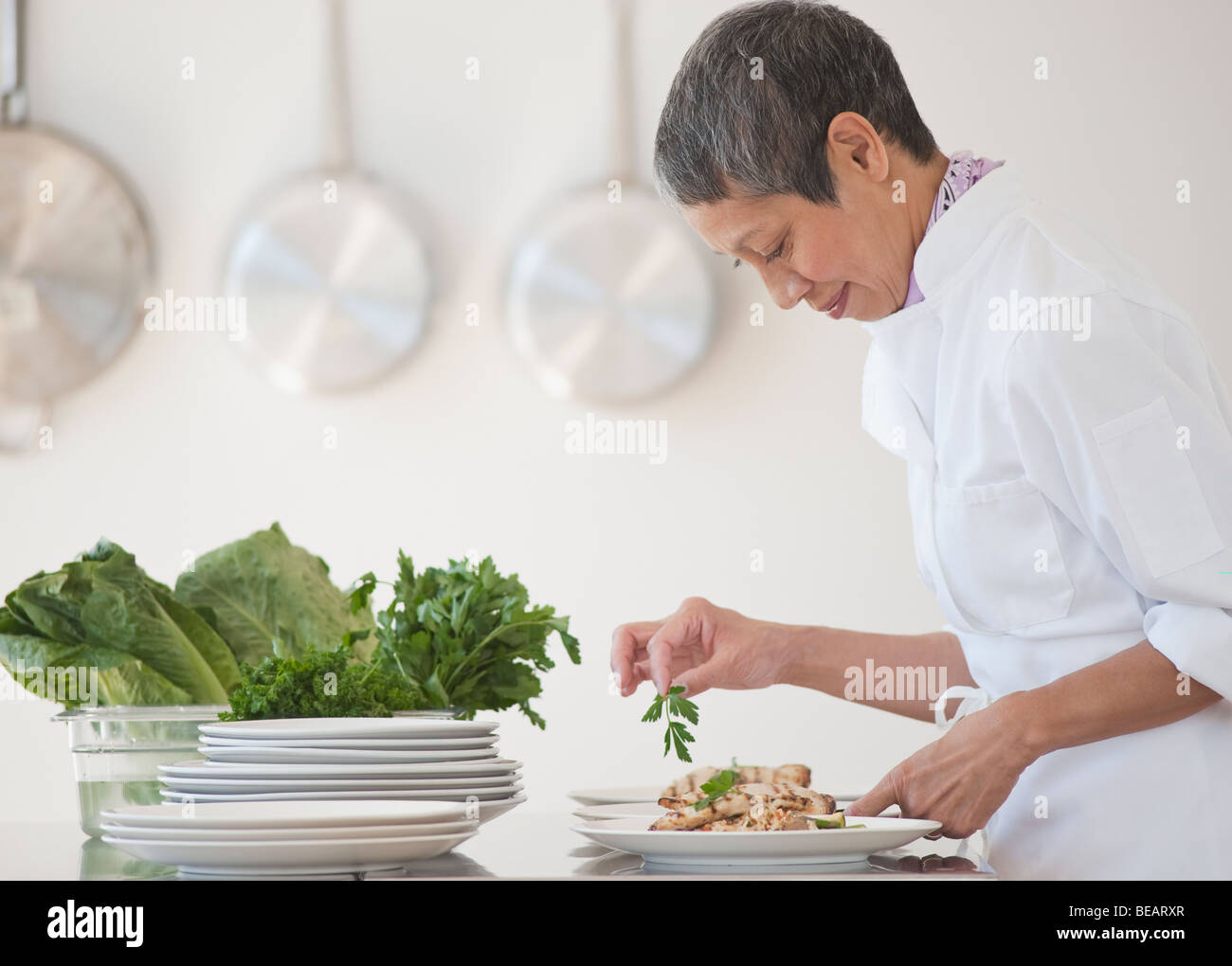 Chinese chef plating meals in professional kitchen Stock Photo