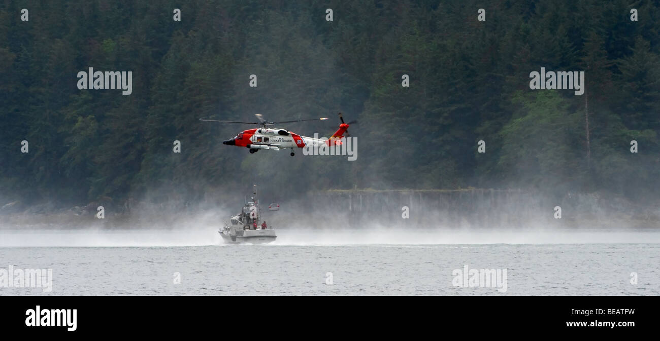 "A Coast Guard Helicopter patrol practices basket lowering on the inland waterways of Alaska." Stock Photo