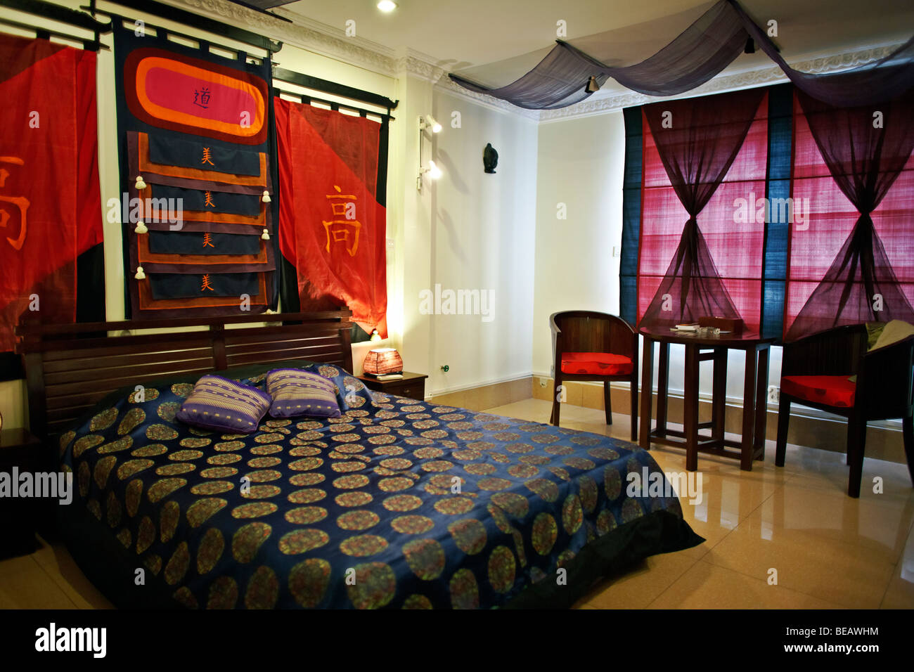Cambodian traditionally decorated Balinese style bedroom suite in a boutique hotel at Phnom Penh, Cambodia S. E. Asia Stock Photo