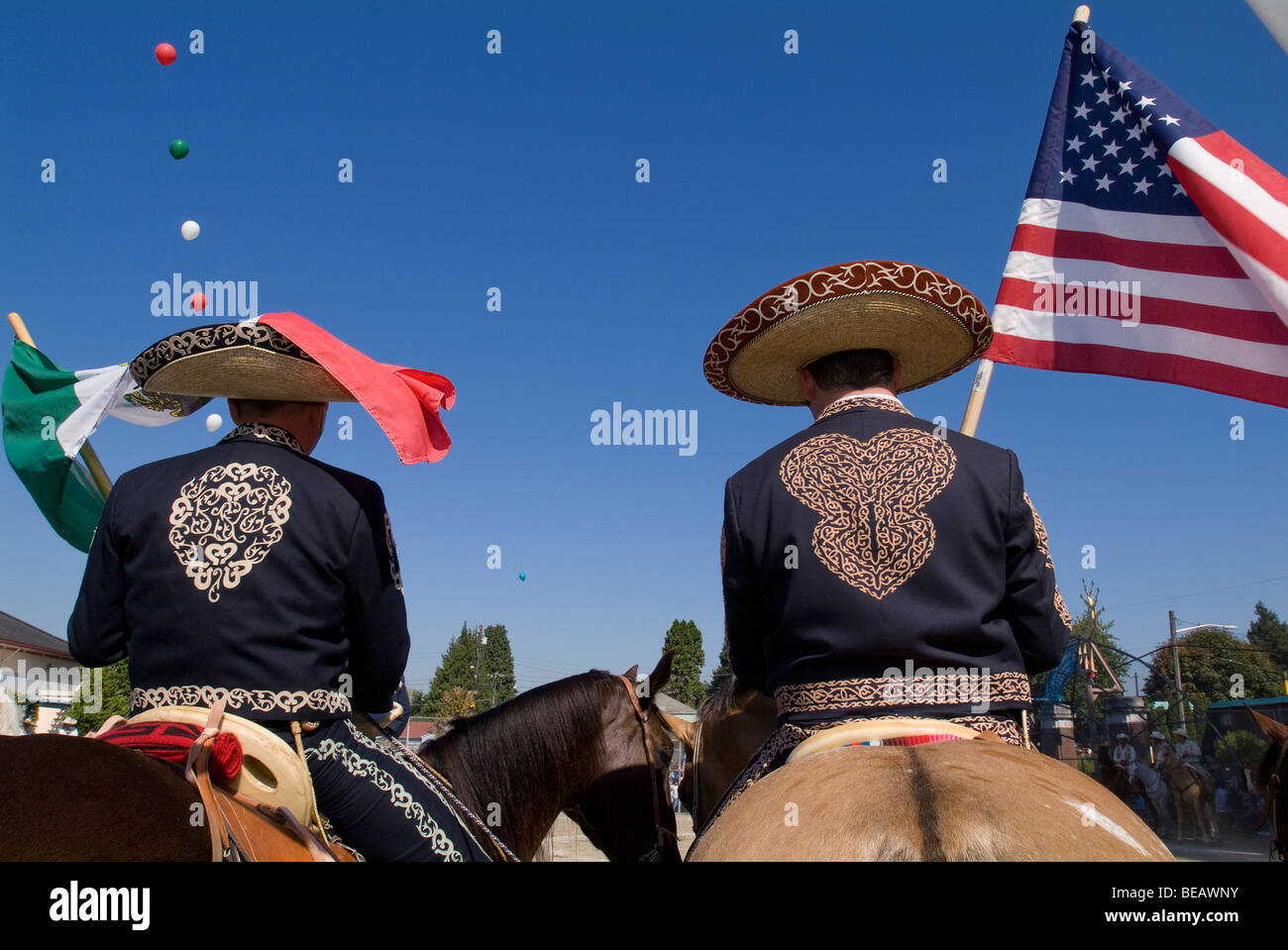 Two Mexican American cowboys holding American and Mexican flags. Stock Photo