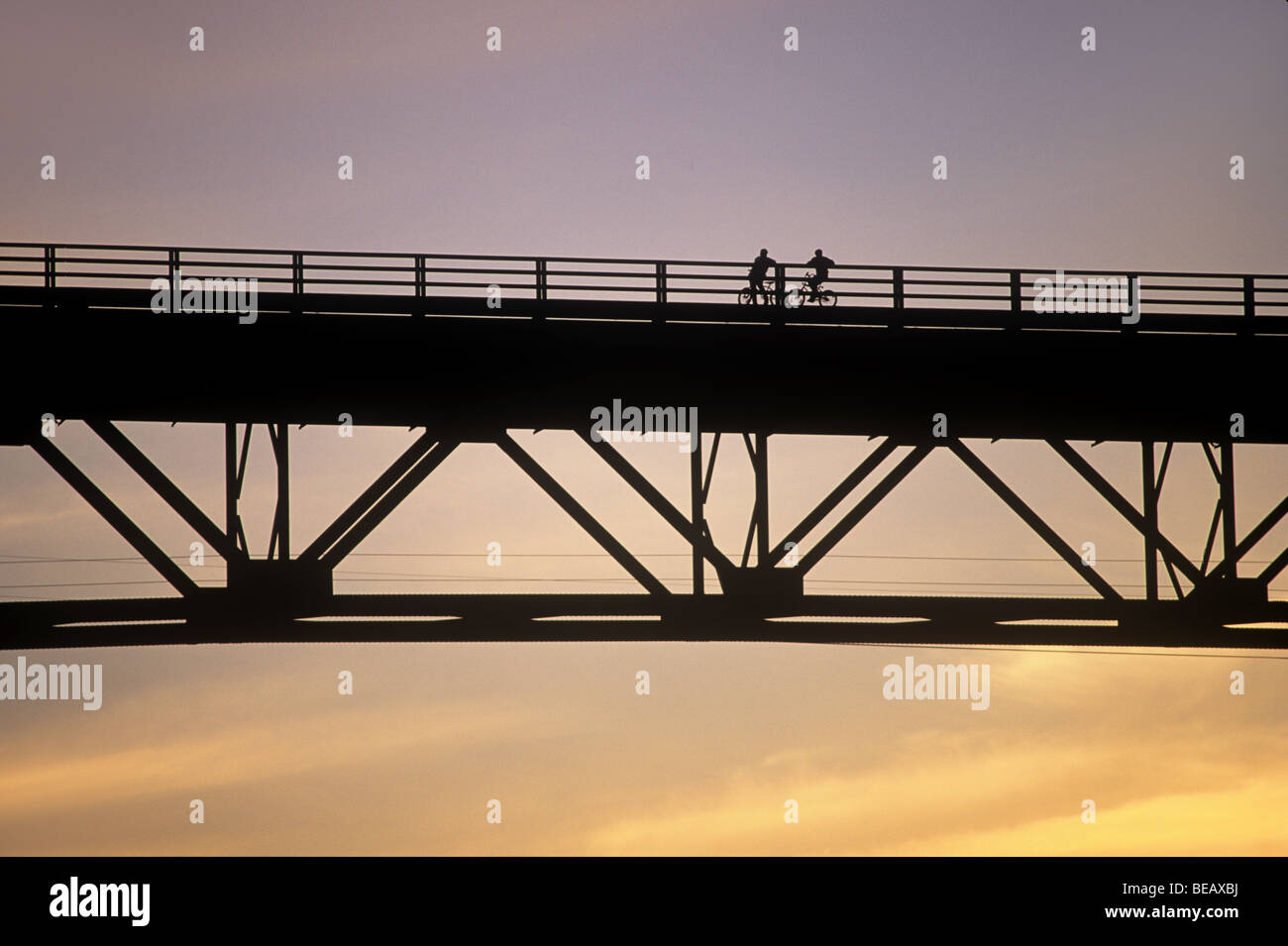 2 bicyclists pause on a bridge Stock Photo