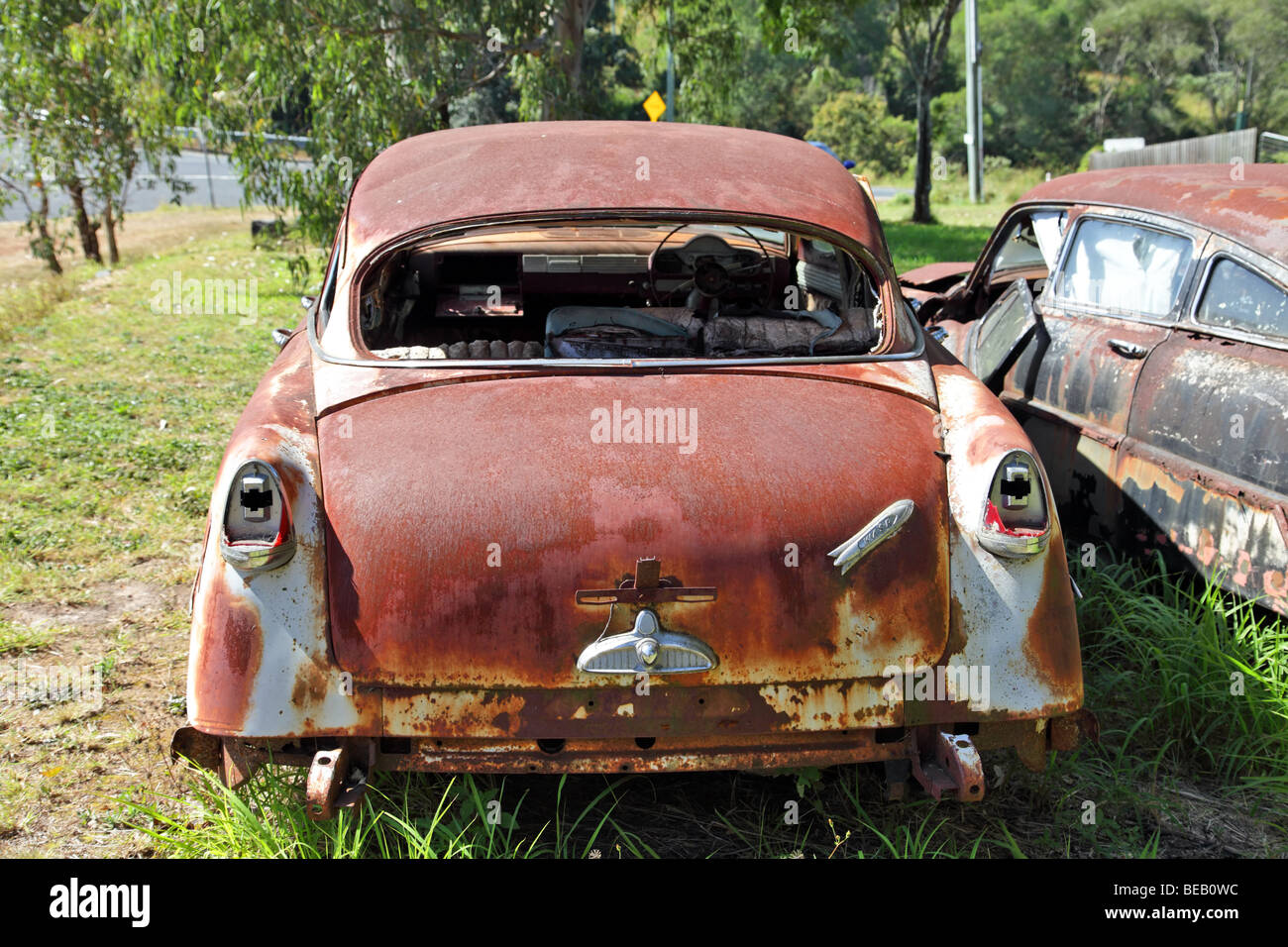 Rusted old cars in a grassy field Hudson Super Swift Stock Photo
