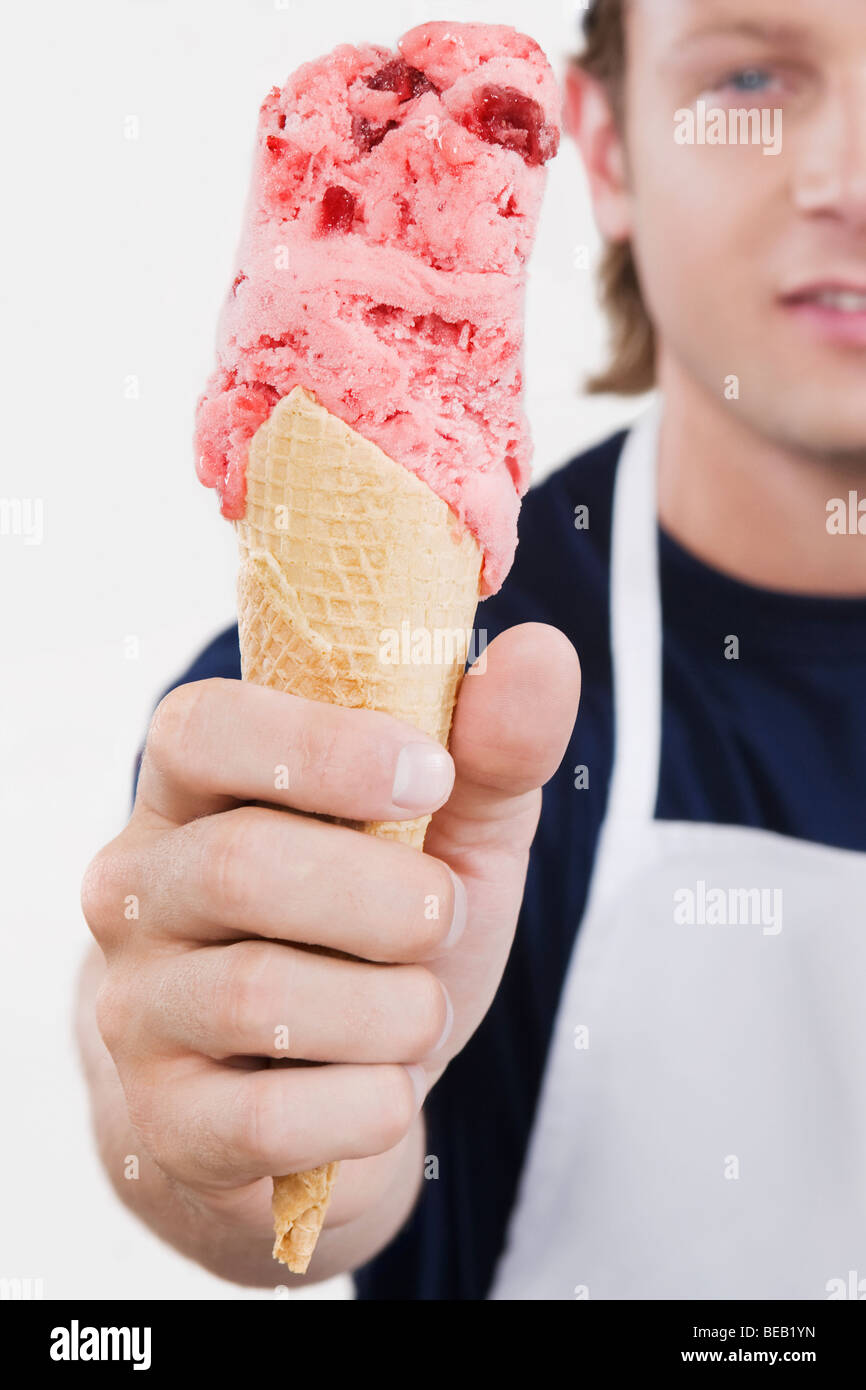 Sales clerk holding an ice cream cone in an ice cream parlor Stock