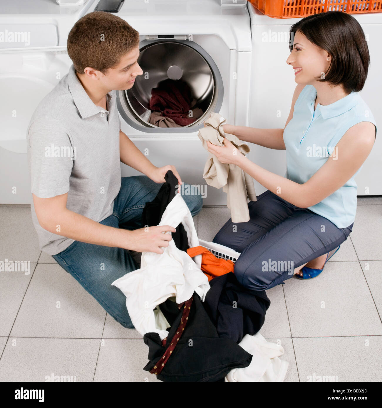 Couple washing clothes in a laundromat Stock Photo Alamy