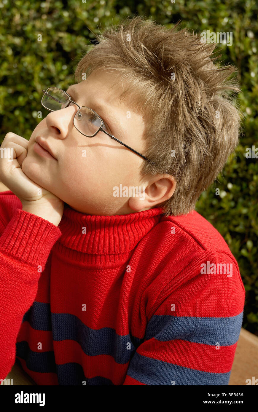 Close-up of a boy with his hand on his chin Stock Photo