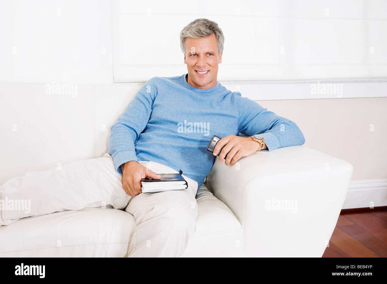 Man reclining on a couch Stock Photo - Alamy