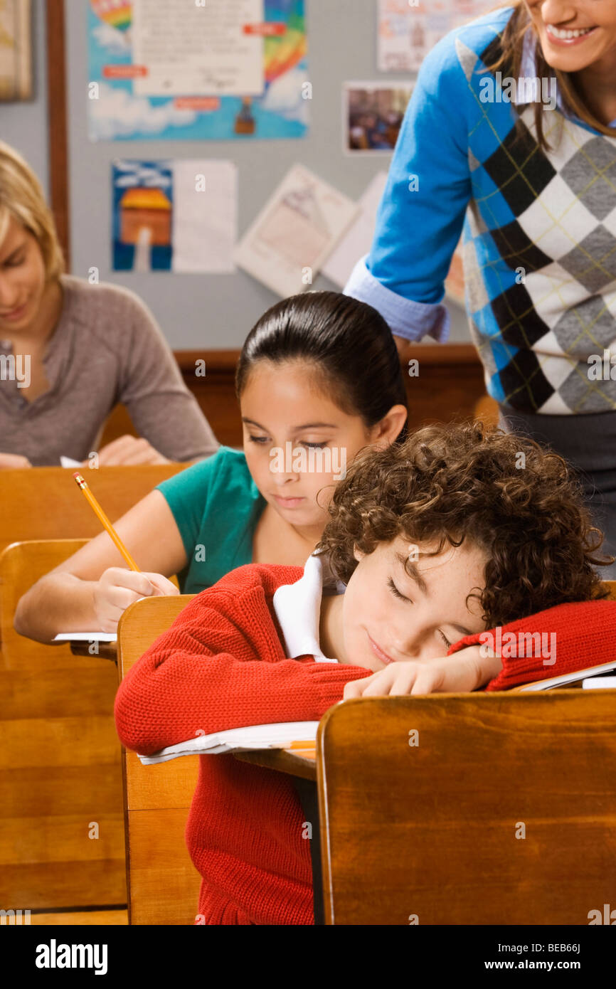 Students studying with a schoolboy sleeping in a classroom Stock Photo ...