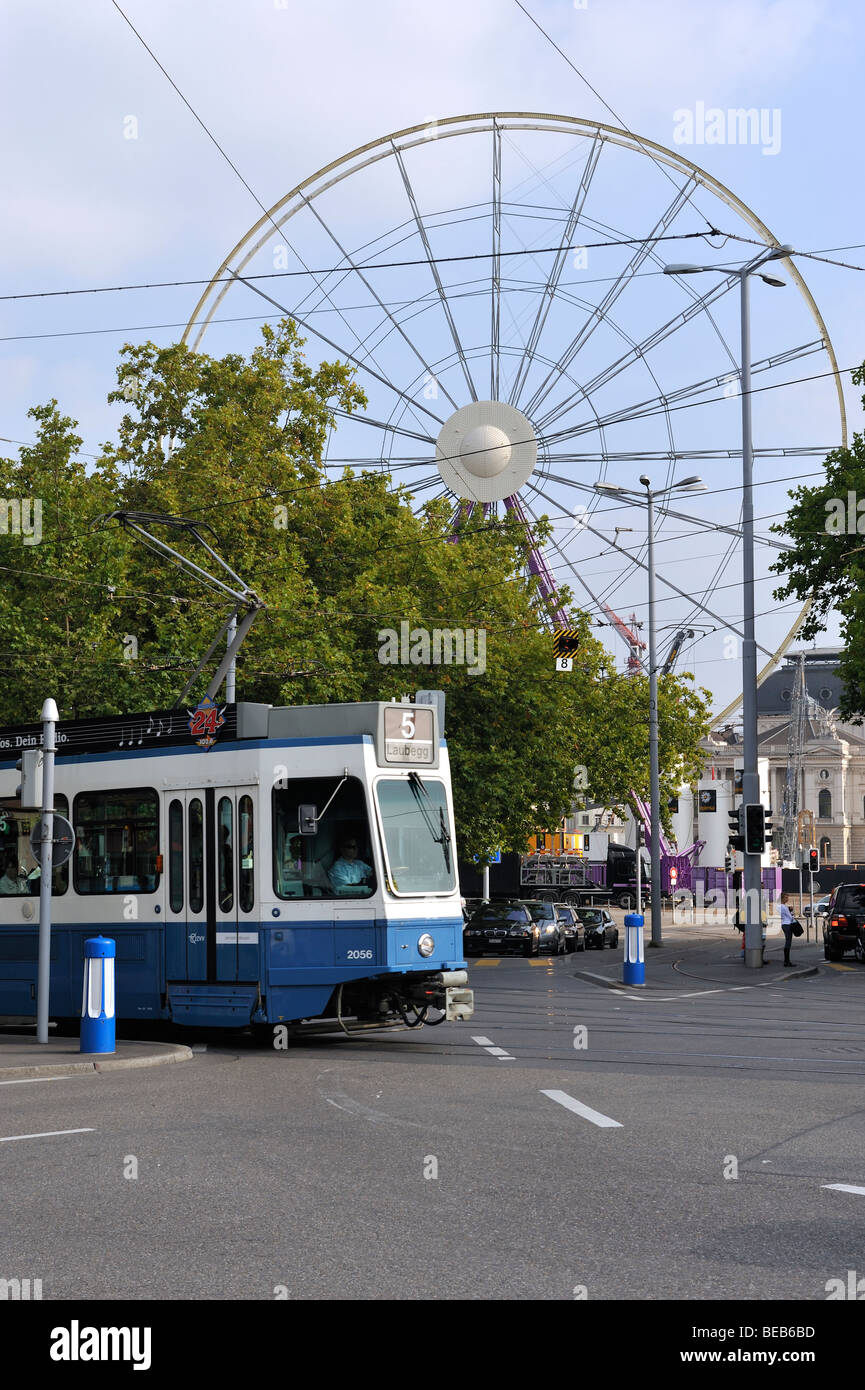 A tram passing by a Ferris Wheel in Zurich Stock Photo