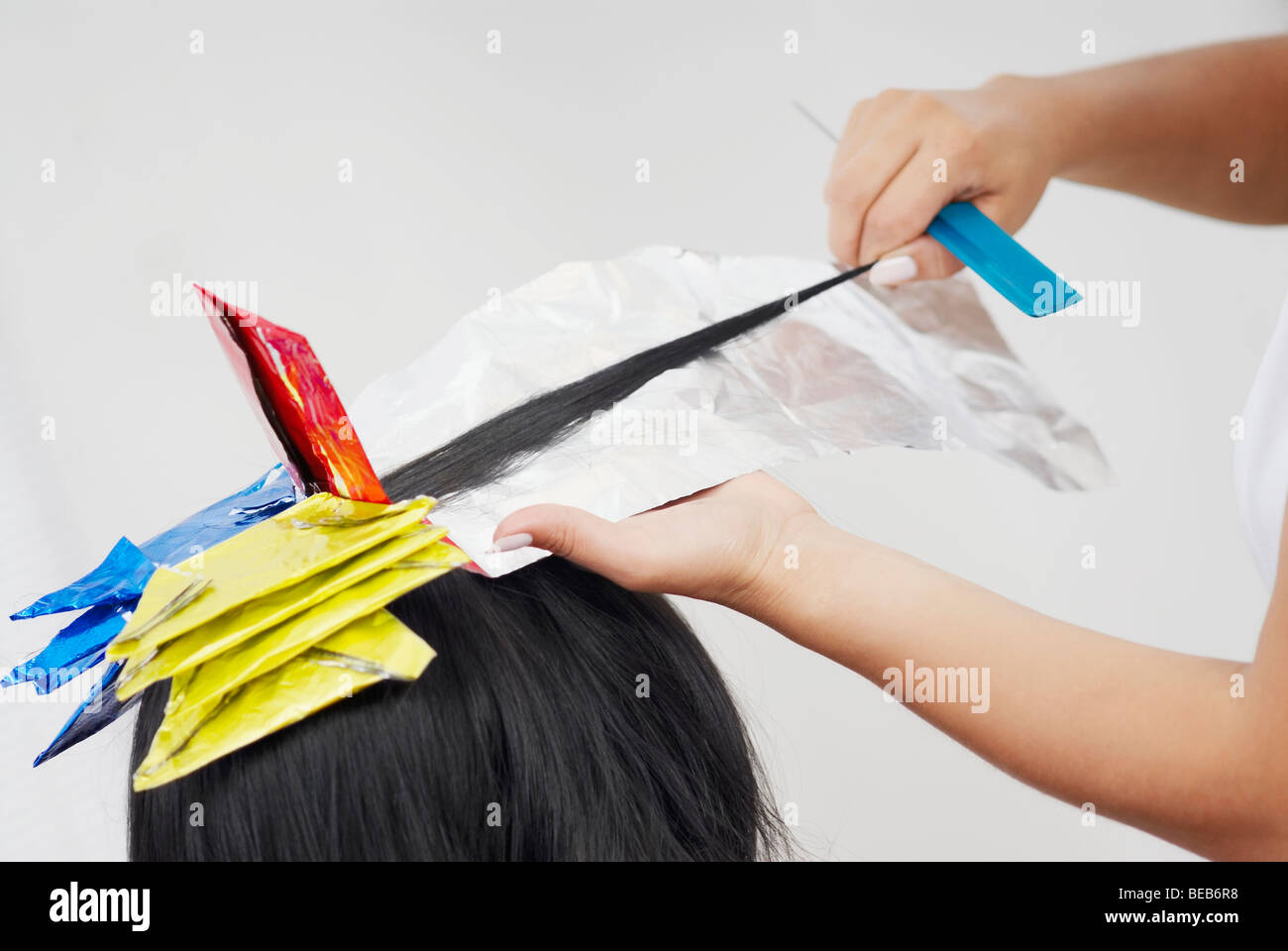 Close-up of a hairdresser's hands coloring a person's hair Stock Photo