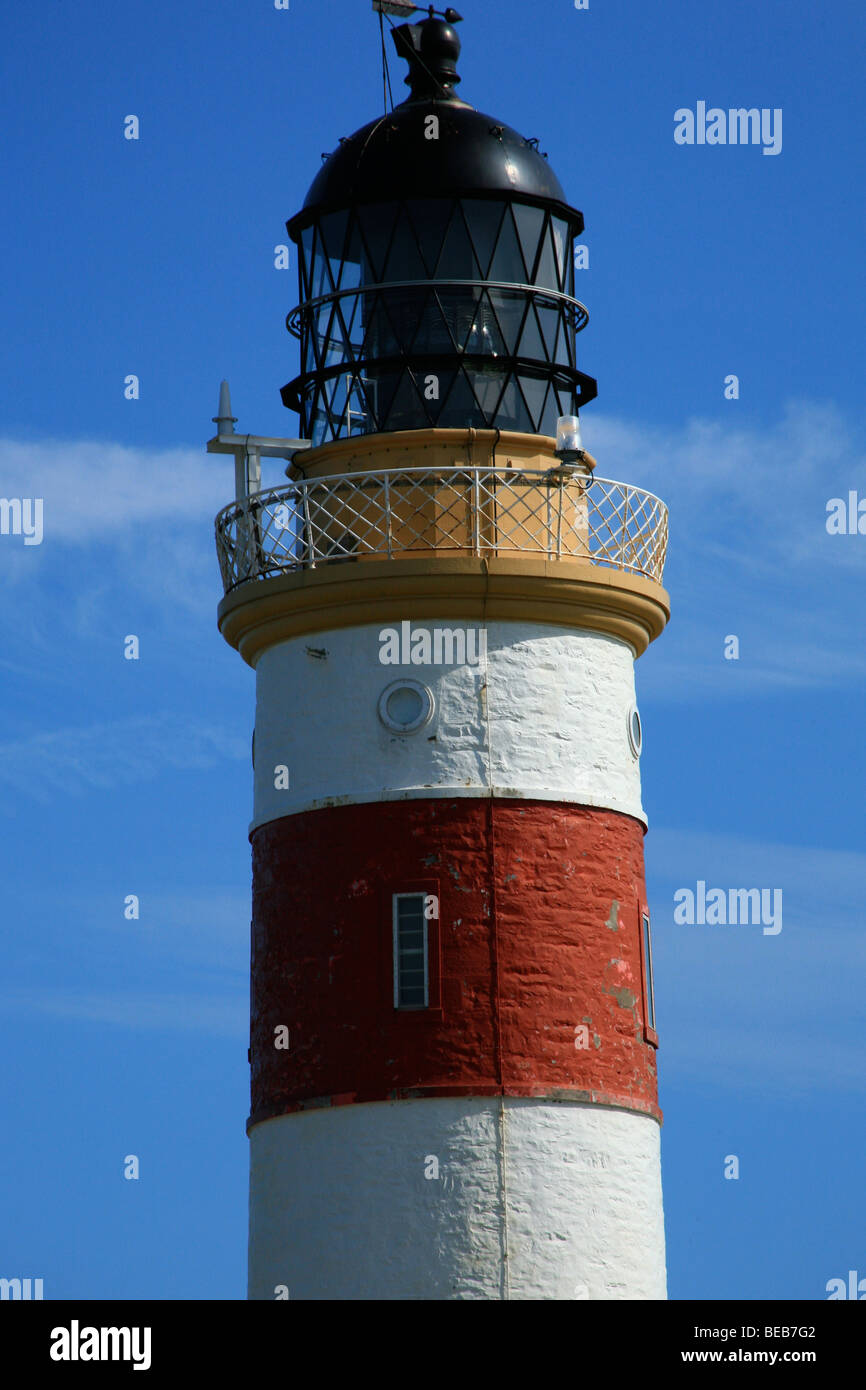 Close up of a red and white lighthouse against a blue sky Stock Photo