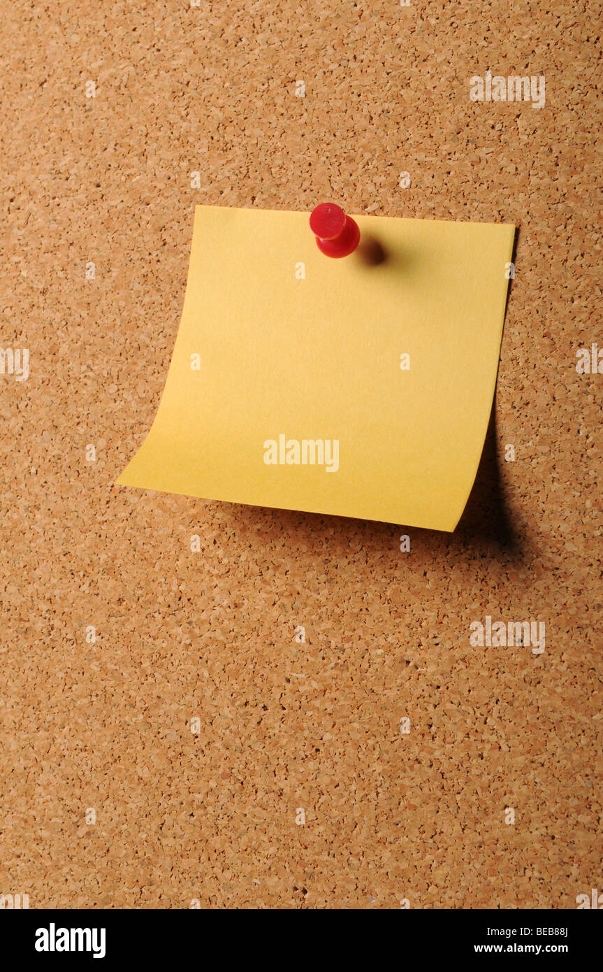 Sticky notepaper with pin on cork board Stock Photo