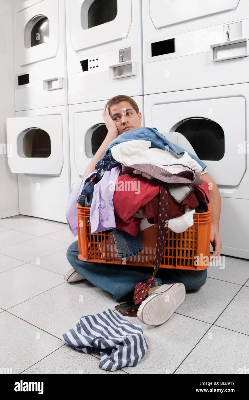 Man with a basket in a laundromat Stock Photo