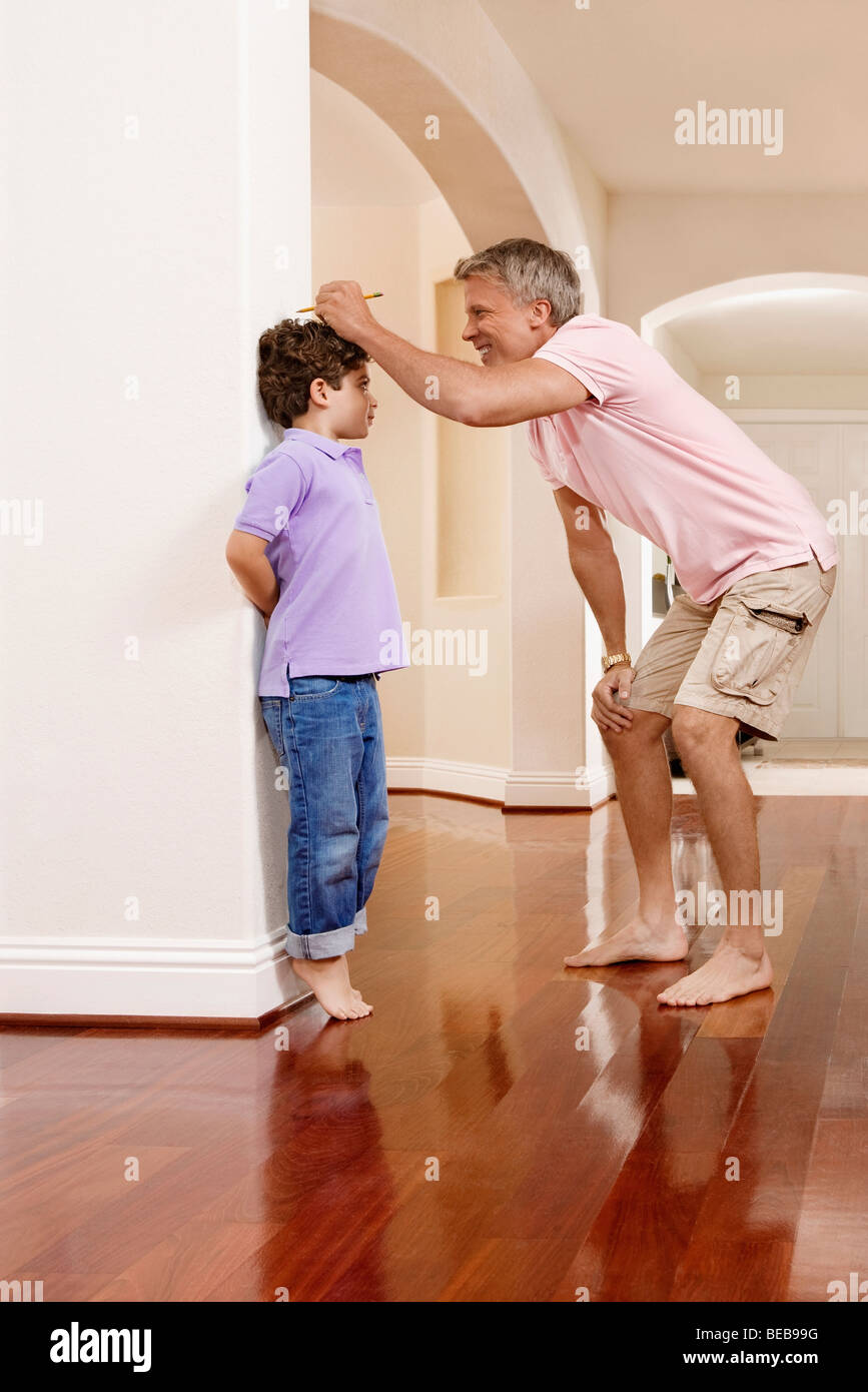 Man measuring his son's height Stock Photo