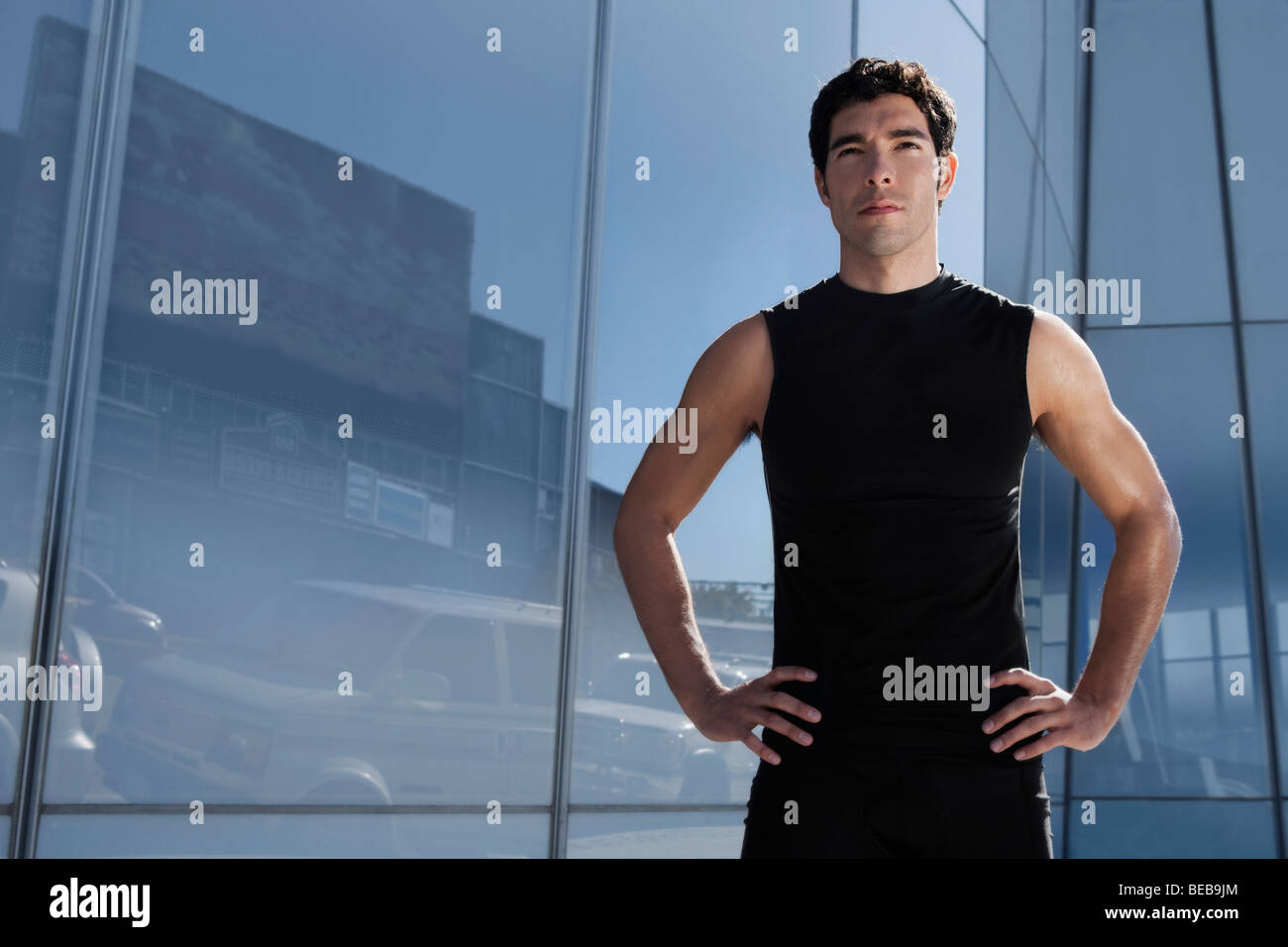 Man standing with arms akimbo Stock Photo - Alamy
