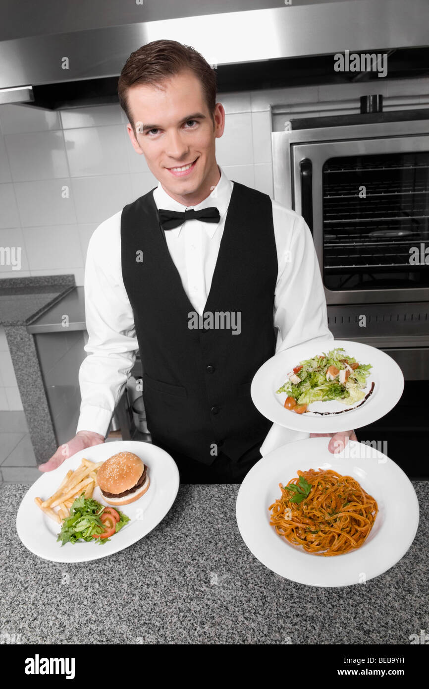 Waiter holding plates of foods Stock Photo Alamy
