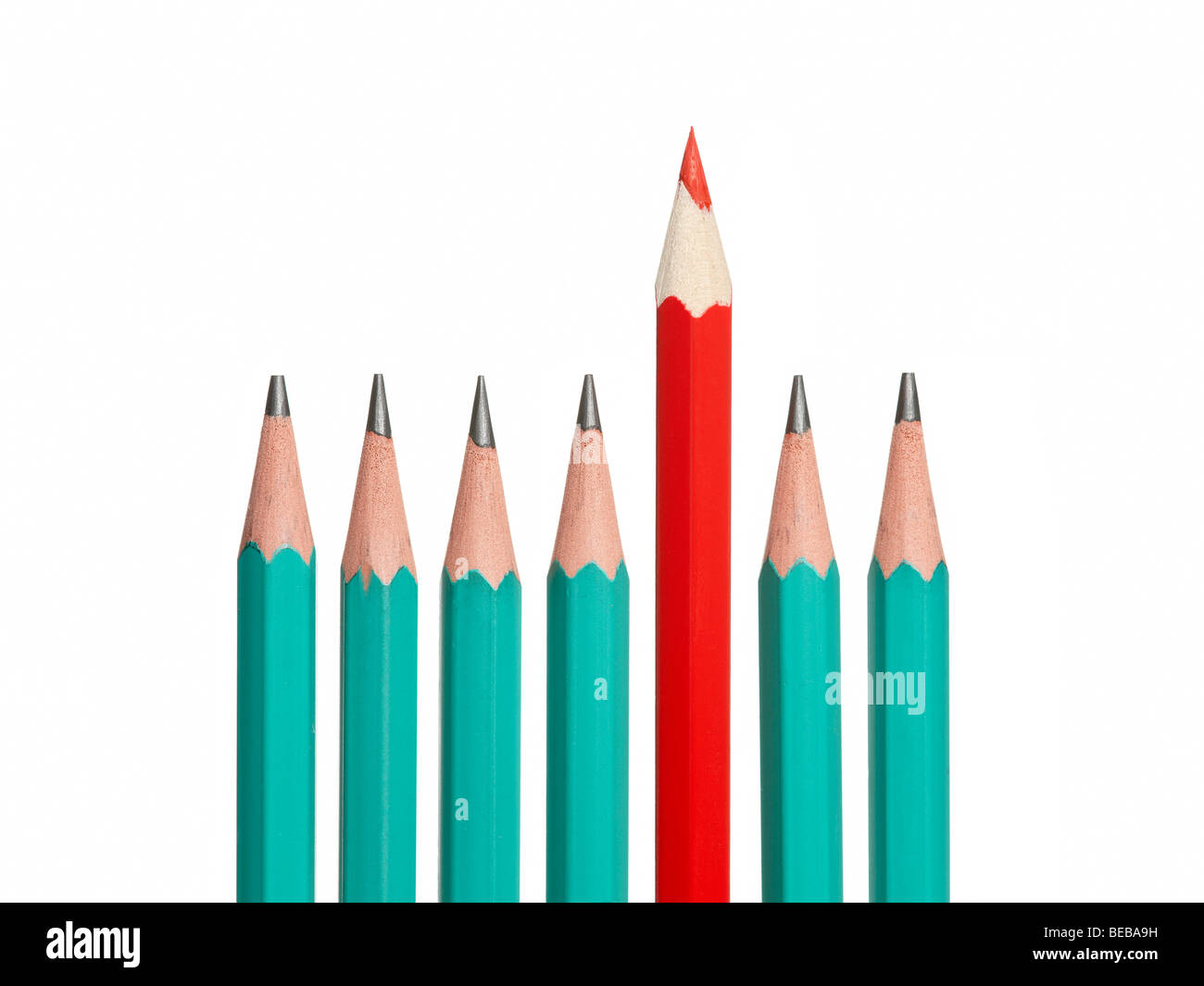 Many identical crayons and an outstanding, brightly colored one - competitive advantage and leadership concept. Stock Photo
