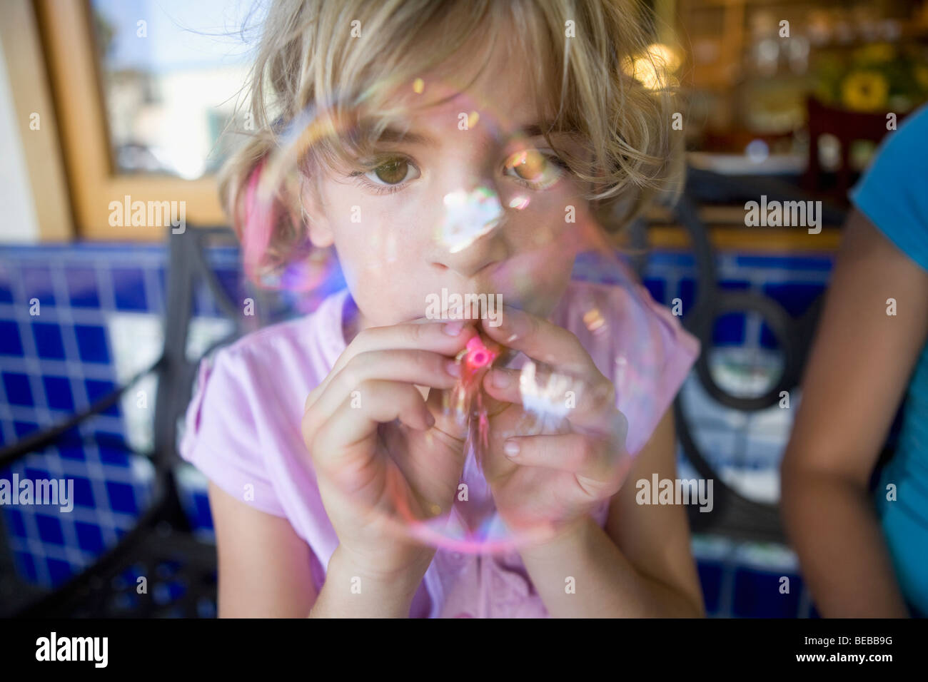 Girl blowing bubbles with a bubble wand Stock Photo