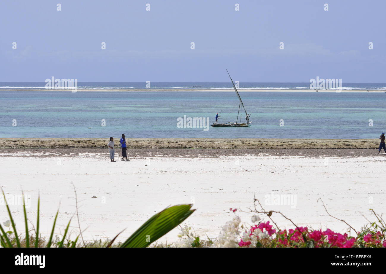 African Men on Diani beach Kenya Africa with boat and sea in background Stock Photo