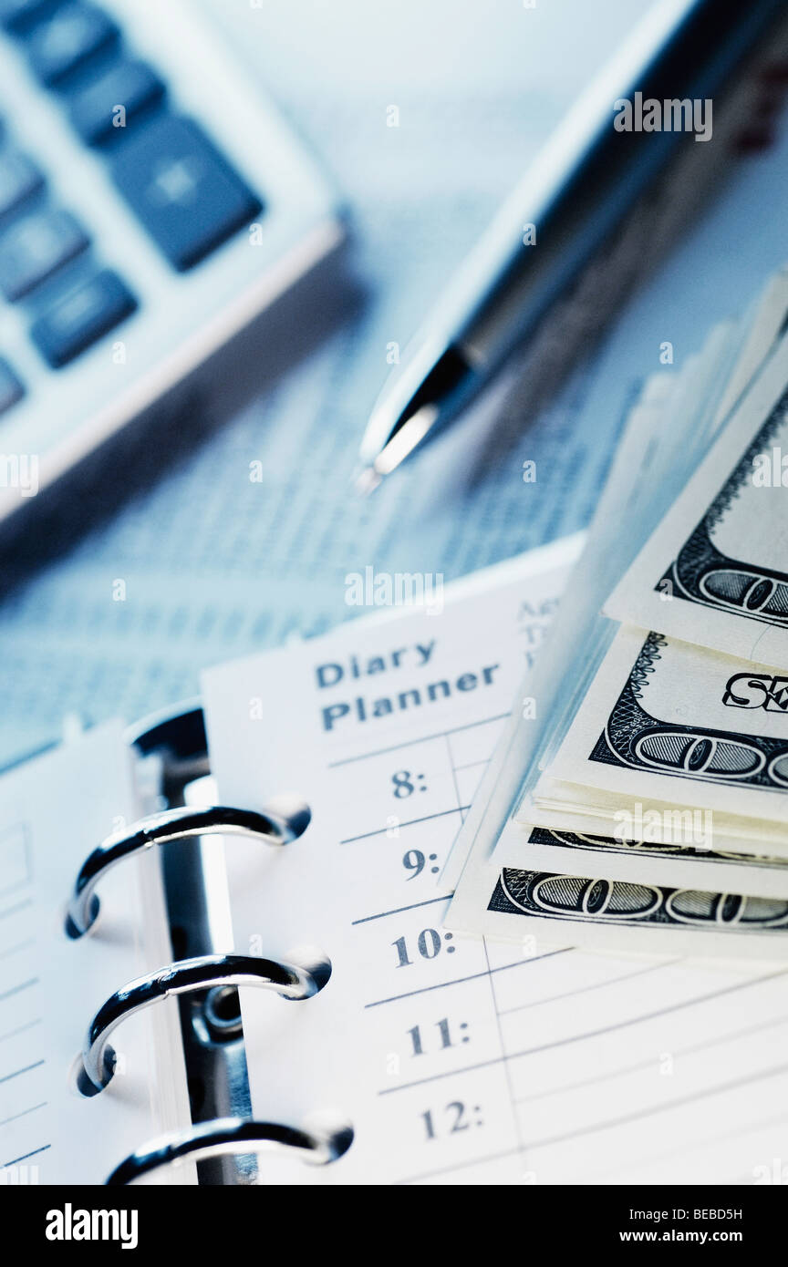 Closeup of a spiral notebook and US paper currency with a calculator