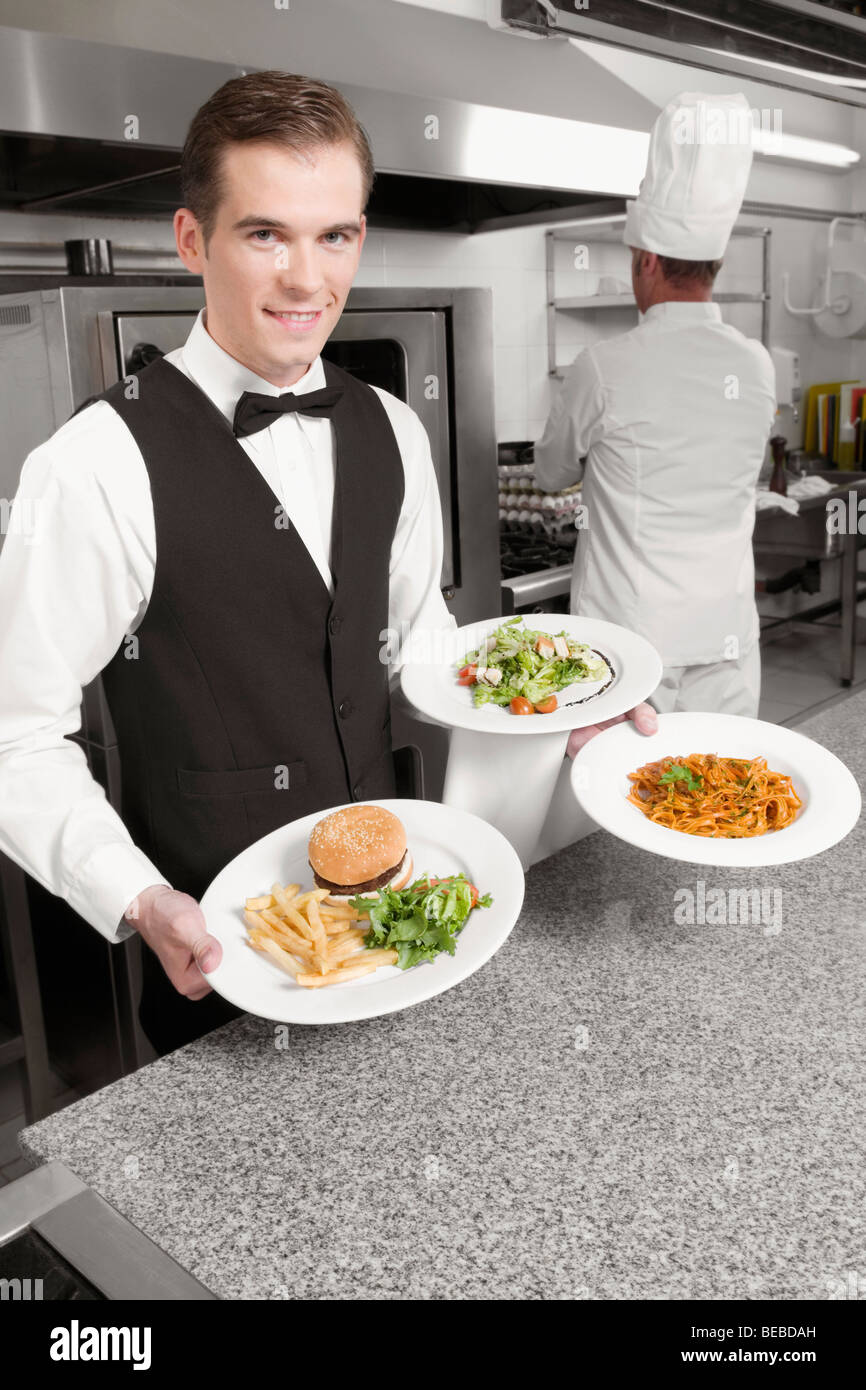 Waiter holding plates of foods Stock Photo