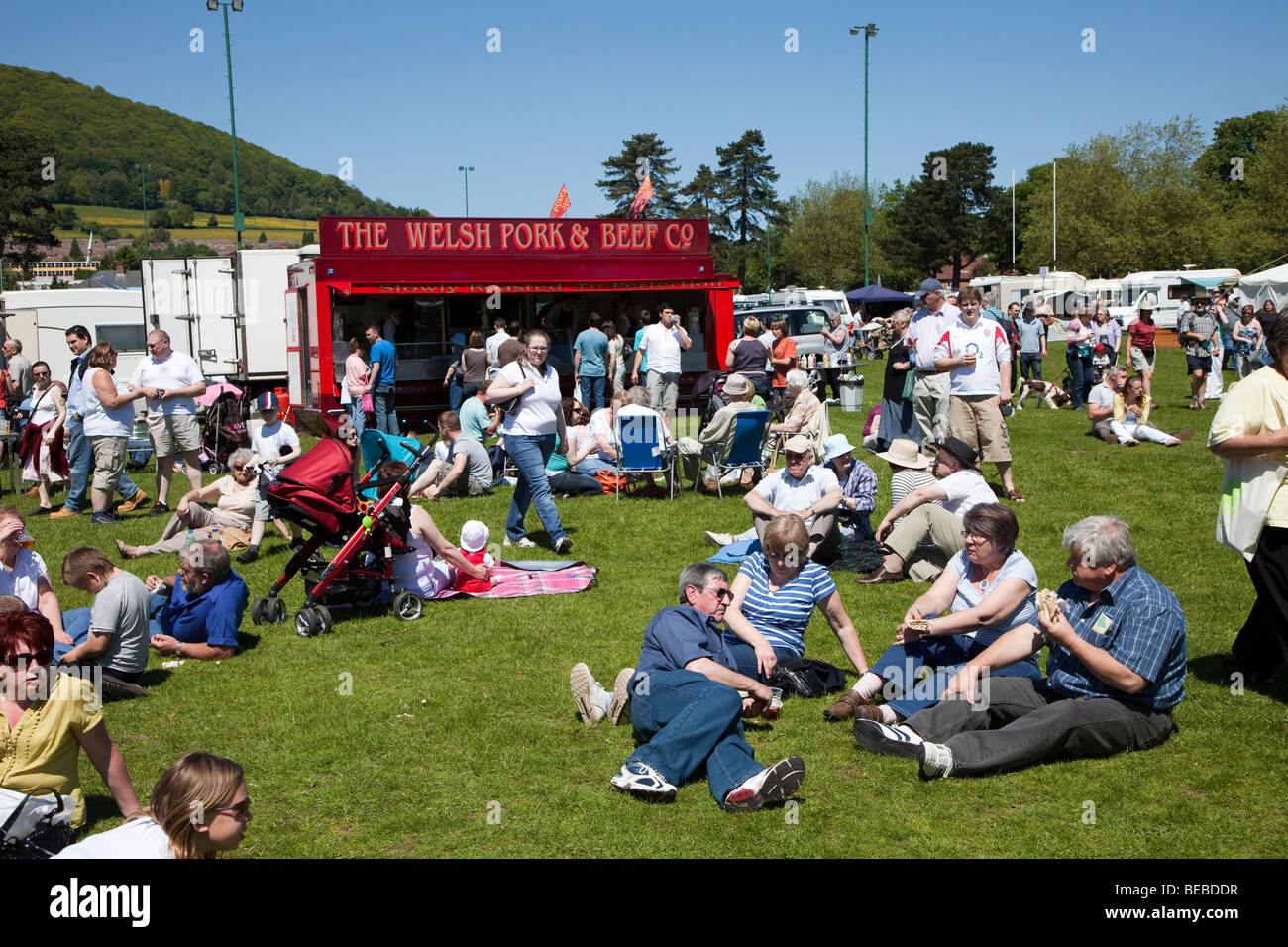 People sitting on grass with fast food van at Abergavenny steam fair