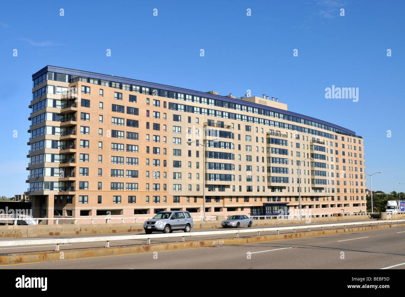 New large modern apartment building next to highway on a clear blue sky day in Quincy, Massachusetts Stock Photo