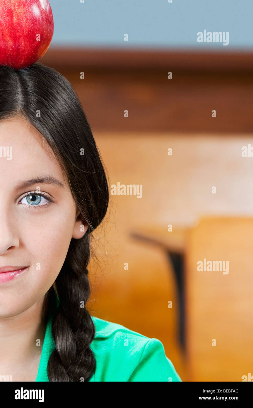Schoolgirl carrying an apple on her head in a classroom Stock Photo - Alamy