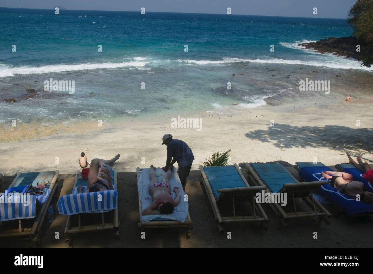 tourist getting a massage at the beach in Bali Indonesia Stock Photo