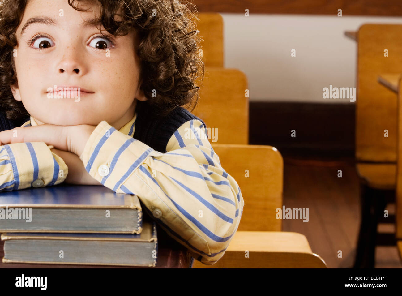 Schoolboy sitting with books in a classroom Stock Photo - Alamy