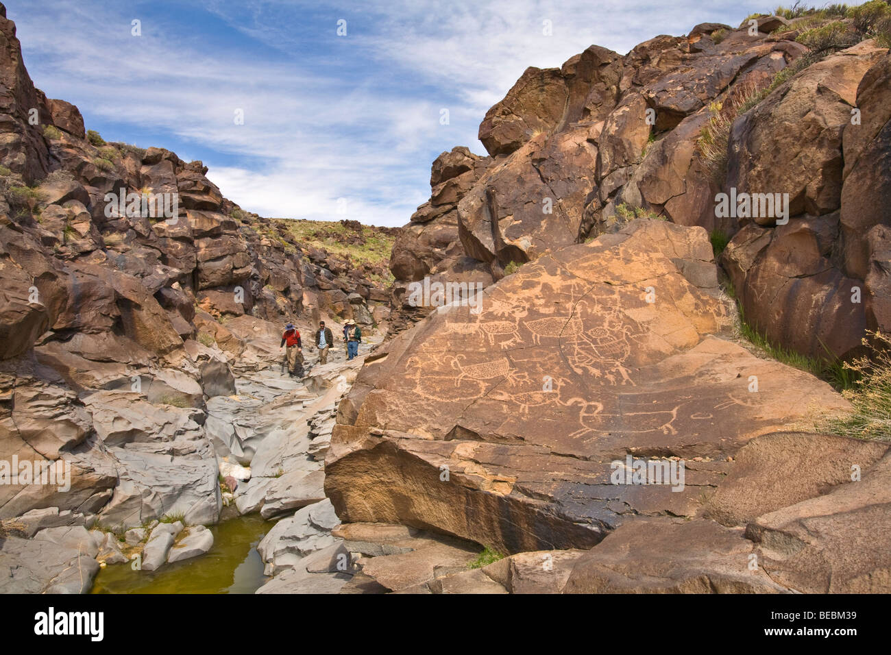 Hikers on tour of Little Petroglyph Canyon, on the China Lake Naval Air Weapons Station, Ridgecrest, California, USA Stock Photo