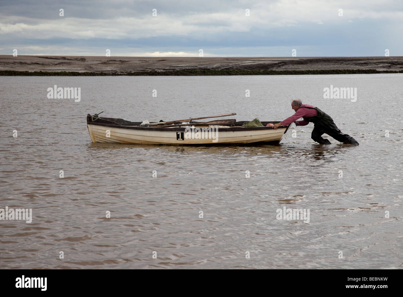 Commercial salmon fisherman pushing a small boat upstream the River Ribble Uk Stock Photo