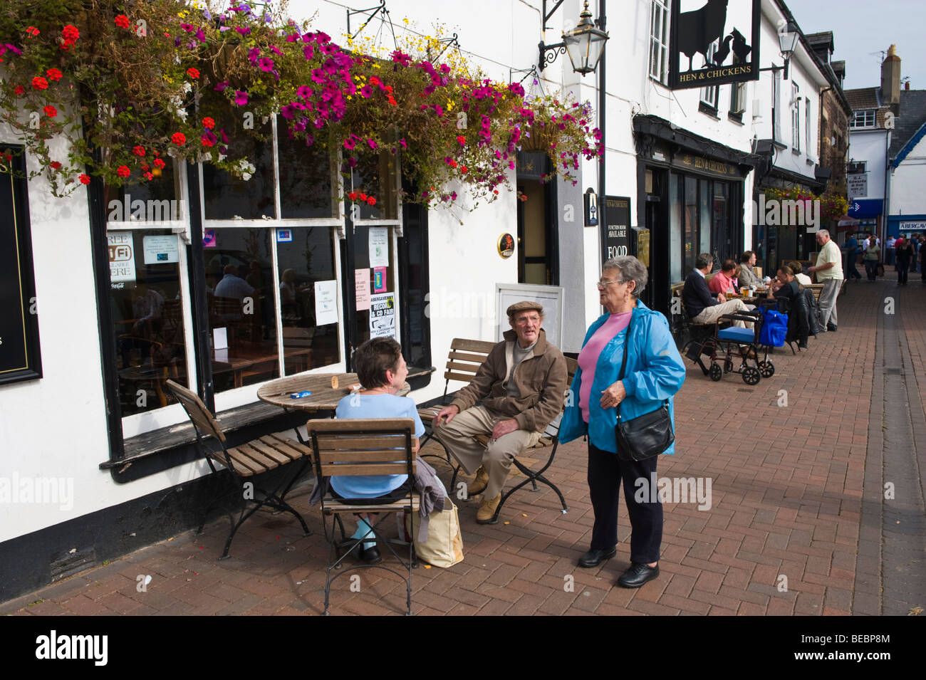 People sat drinking on sunny afternoon outside Hen and chickens pub at Abergavenny Monmouthshire South Wales UK Stock Photo