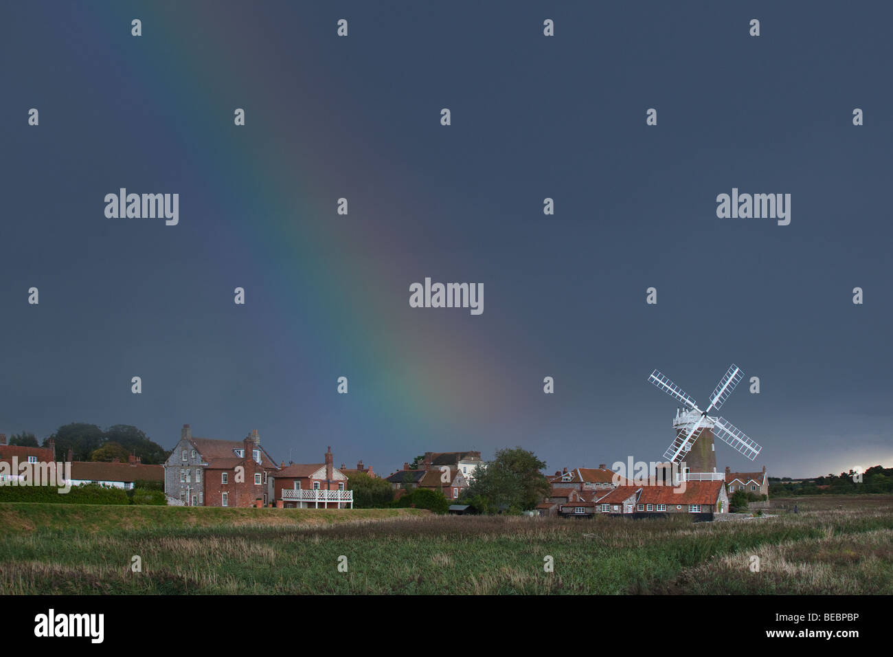 Storm and rainbow over Cley Village and Windmill on the North Norfolk Coast England in late summer Stock Photo