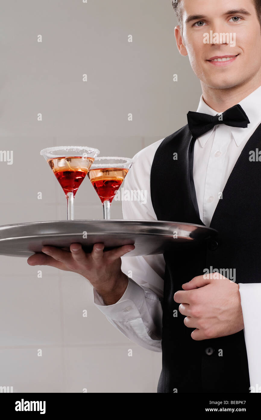 Portrait of a waiter holding a tray of martini glasses Stock Photo Alamy