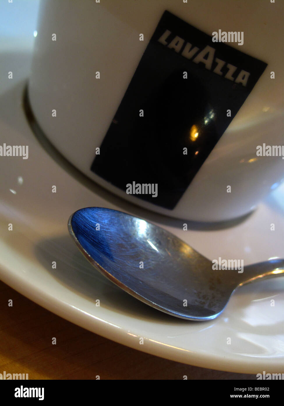 A spoon rests in the saucer of a Lavazza coffee cup in a coffee shop in Canterbury, Kent. Stock Photo