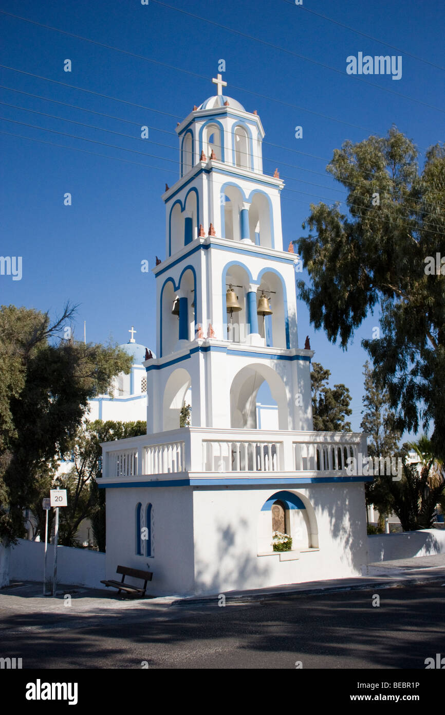 Beautiful characteristic white church bell tower against blue sky, in the town of Kamari, Santorini, Greece. Stock Photo