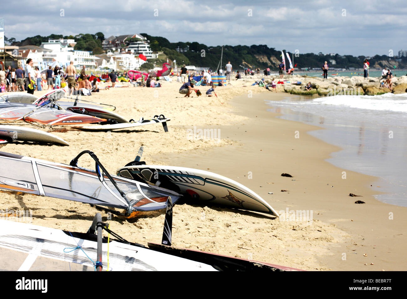 Colourful Windsurfing Boards And Sails Laying On A Sandy Beach Waiting To Be Used On The Shoreline Before An offshore Race Or Competition Stock Photo