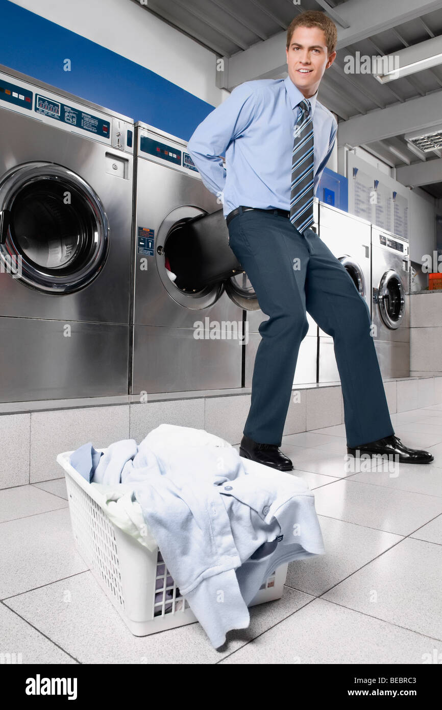 Businessman putting a briefcase into a washing machine Stock Photo