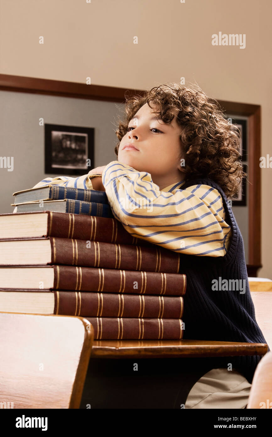Schoolboy sitting with books in a classroom Stock Photo - Alamy
