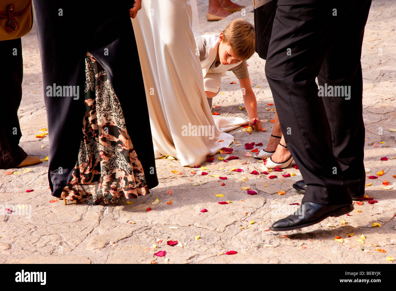 Young ring bearer making sure the flower petals are all picked up - wedding in Eze, Provence France Stock Photo