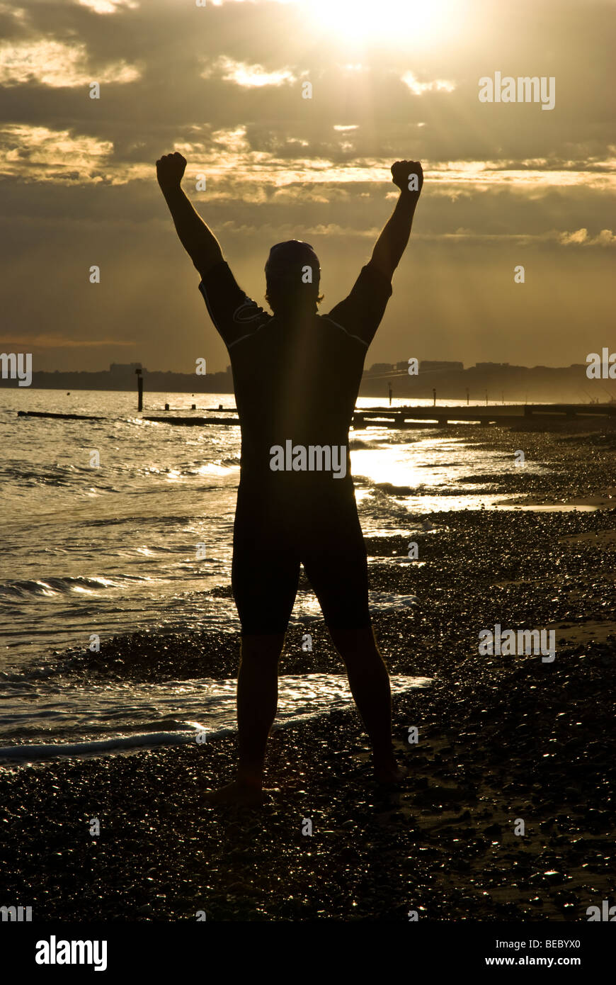 Triathlete lifting arms in celebration. Stock Photo