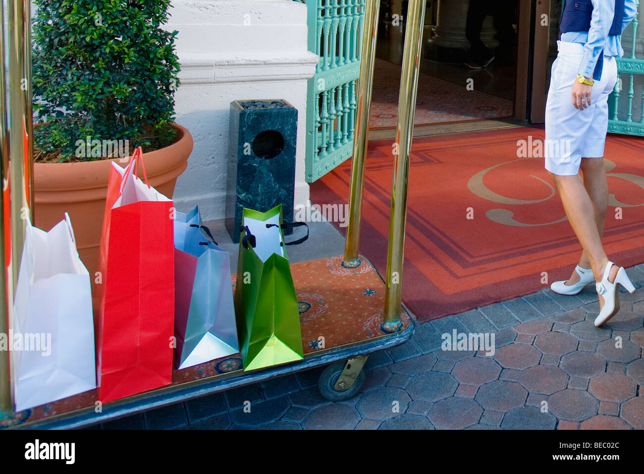 Woman entering in a hotel with luggage in a luggage cart, Biltmore
