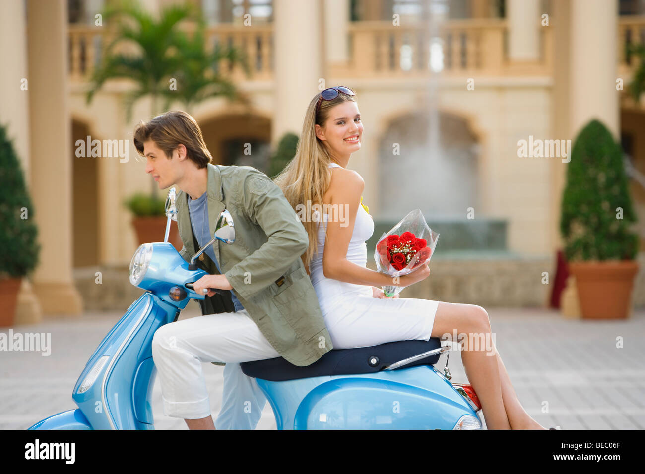 Couple sitting on a moped, Biltmore Hotel, Coral Gables, Florida, USA Stock Photo