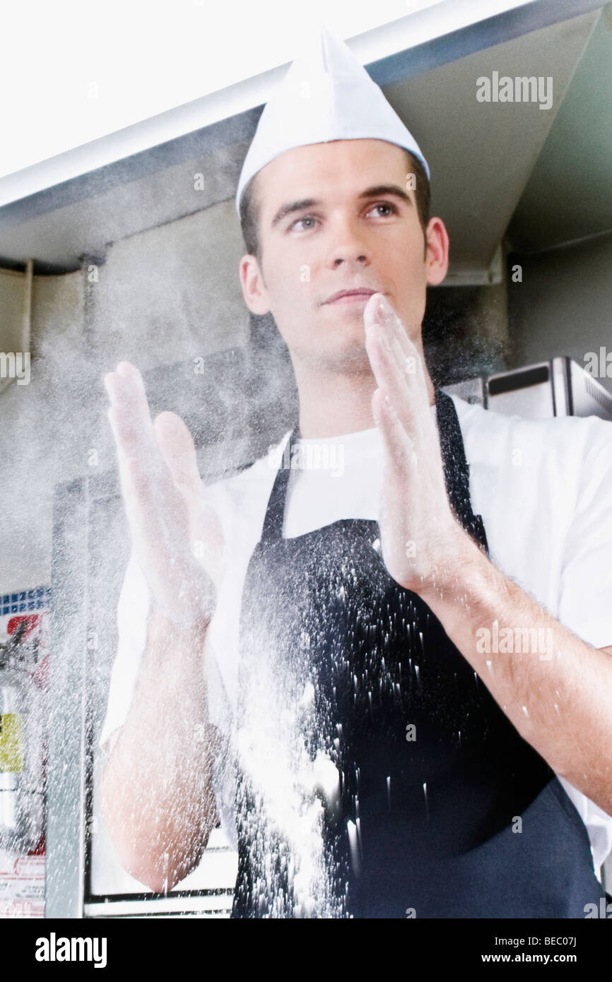 Chef dusting hands with flour Stock Photo Alamy