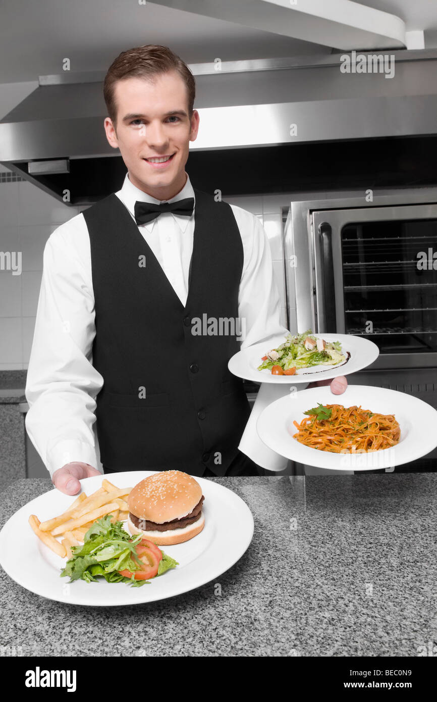 Waiter holding plates of foods Stock Photo Alamy